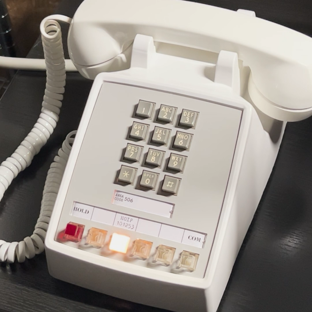 A white Western Electric 2565 key telephone set, with one key (light) illuminated.